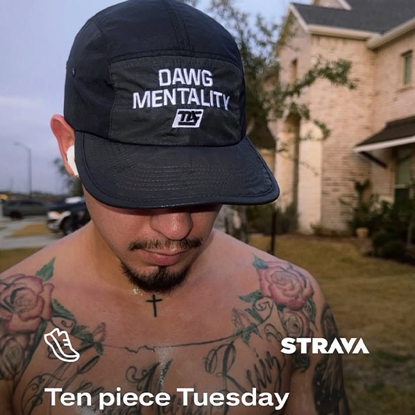 Man wearing a black cap with 'DAWG MENTALITY' text, outdoors with a house in the background.